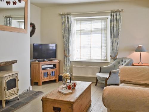 a living room with a couch and a television at Kingsley Cottage in Instow