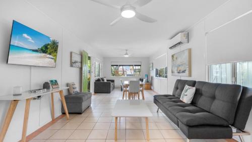 a living room with a couch and a table at Coastal Palms Hideaway in Bongaree