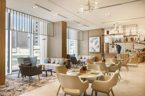 a rendering of a restaurant with tables and chairs at Hilton Garden Inn Dubai Business Bay in Dubai