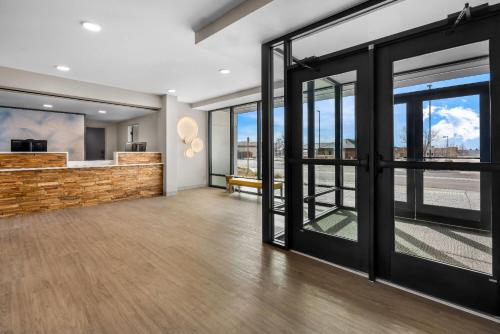 an empty lobby with glass doors and a counter at ECHO Suites Extended Stay by Wyndham Colorado Springs Airport in Colorado Springs
