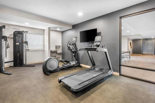 a gym with a treadmill and a flat screen tv at ECHO Suites Extended Stay by Wyndham Colorado Springs Airport in Colorado Springs