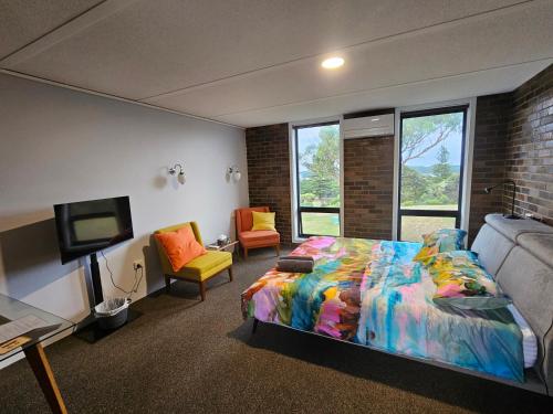 a bedroom with a bed and a flat screen tv at Discovery Views in Nelson