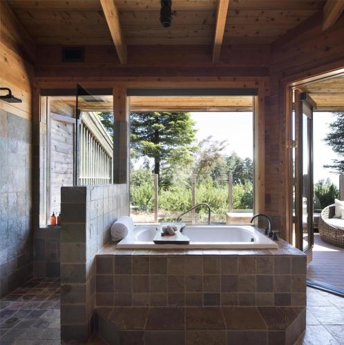 a bath tub in a room with a large window at Alila Ventana Big Sur in Big Sur