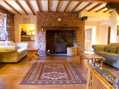 a living room with a stone fireplace and a couch at West Wing- Ukc4914 in Timberscombe