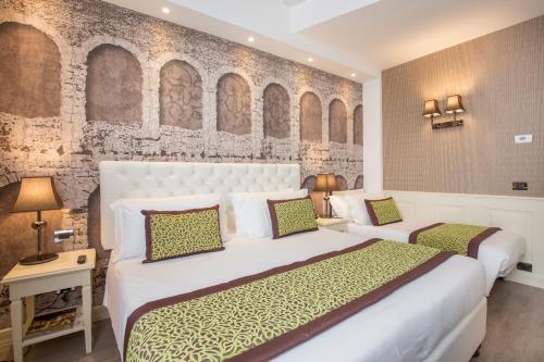 a bedroom with a large white bed and a wall with arches at Hotel San Pietro in Verona