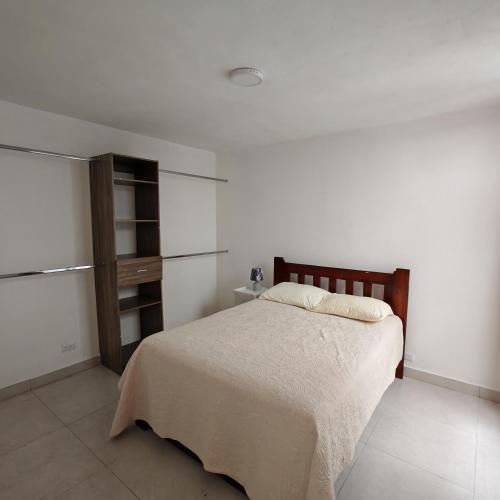 a bedroom with a bed in a white room at Apartamentos Las Orquideas in San Pedro