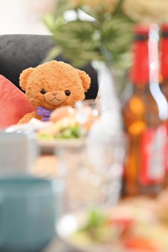 a teddy bear sitting on a chair with a plate of food at INUYAMA BASE Vacation rental in Inuyama