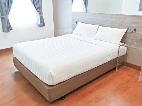 a bed with white sheets and pillows in a bedroom at Red Planet Cebu in Cebu City