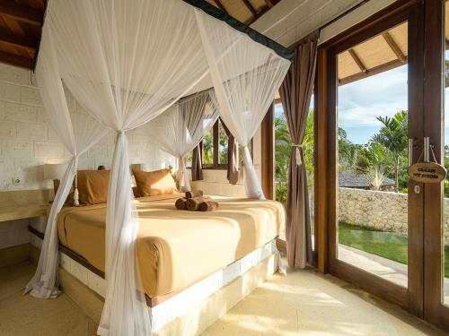 a bedroom with a bed with a canopy at Biu Biu Resort Bali in Jimbaran
