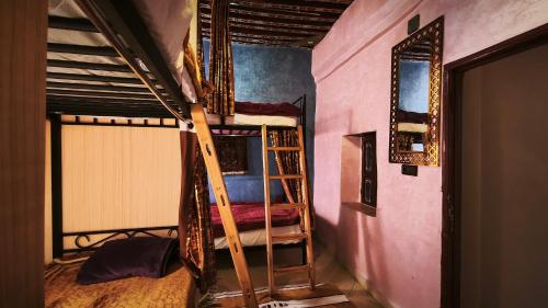 a room with two bunk beds with a ladder at La Kasbah Salam Hostel in Fez