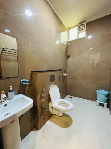 a bathroom with a toilet and a sink at Shree Ram Palace in Chhatikara