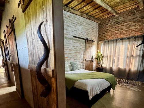 a bedroom with a bed in a brick wall at Syeta Bush Lodge - Luxury Bush Villa in Crocodile Valley Estates