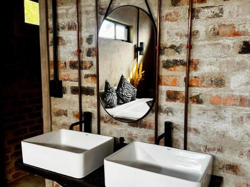a bathroom with two sinks and a mirror at Syeta Bush Lodge - Luxury Bush Villa in Crocodile Valley Estates