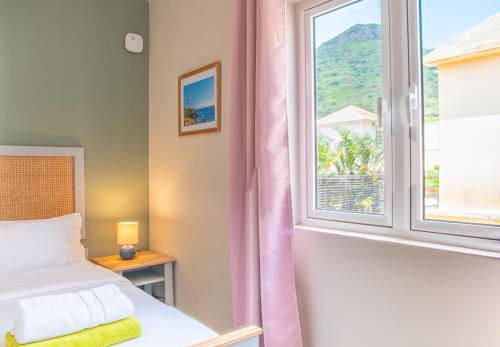 a bedroom with a bed and a window at Bois Bleu Bed And Breakfast in Tamarin