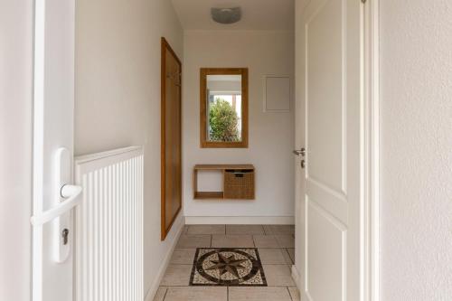 a hallway with a mirror and a tile floor at Haus im Halligweg 20 in Nordstrand