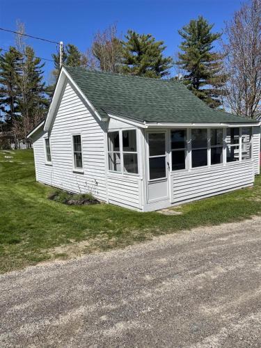 a white house on the side of a road at THE SHOPPE LIMIT 3 cabin in North Sebago