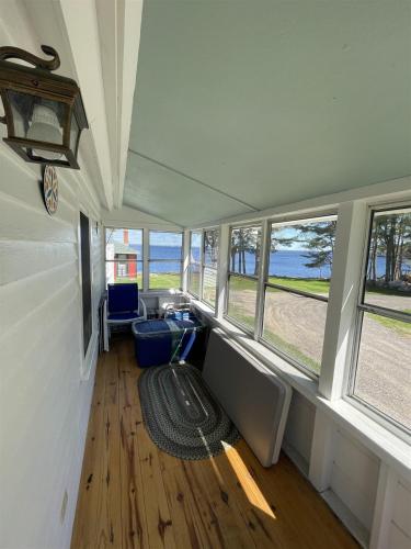 a living room with windows and a couch and a rug at THE SHOPPE LIMIT 3 cabin in North Sebago