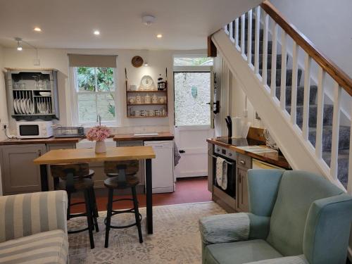 a kitchen with a table and a staircase in a house at Millgate Cottage in Conwy
