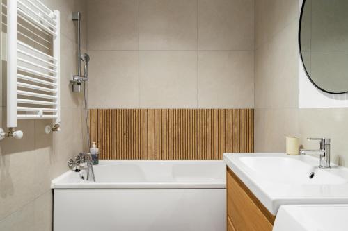 a bathroom with a tub and a sink and a mirror at Sika Platinum Apartment - cazare premium Arad - self check-in in Arad