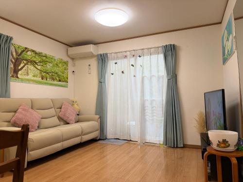 a living room with a couch and a window at 東京田園平安旅館 in Kawaguchi