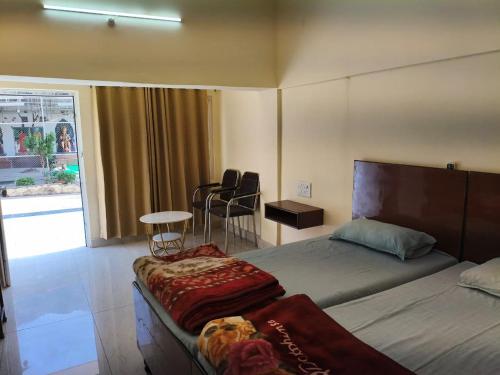 a bedroom with a bed and a table and chairs at Sai Devine Abode Of SAI at Sri Sathya Sai ghaat in Rishīkesh