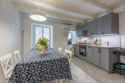 a kitchen with a table with a vase of flowers on it at Veli Lošinj Old Town Apartments in Veli Lošinj