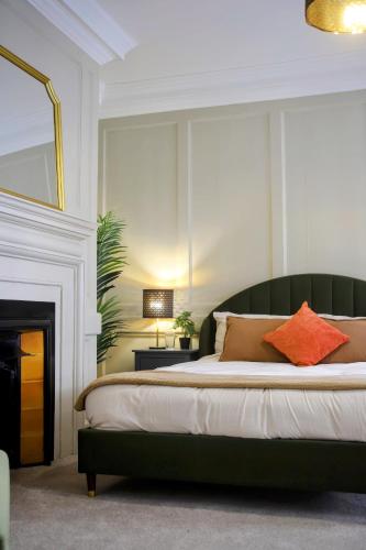 a bedroom with a bed with a fireplace and a mirror at SixCheapStreet in Newbury