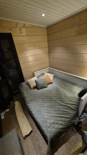 a large bed in a room with wooden walls at Sauna by Lake Saimaa in Savonlinna