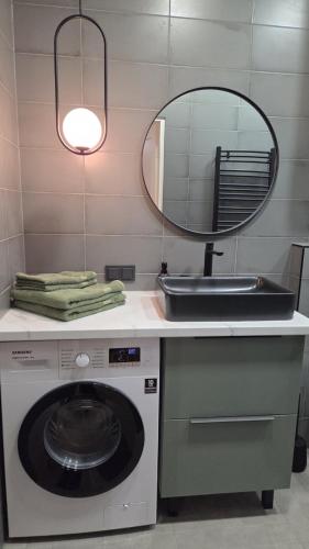 a bathroom with a sink and a washing machine at Peetri Plats Border Apartmens in Narva