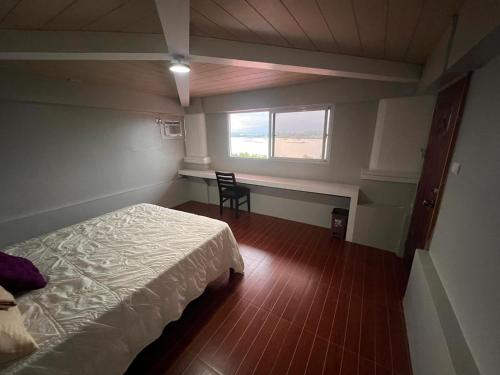 a bedroom with a bed and a chair and a window at Palawan Coliving - Palawan Coworking in Puerto Princesa City