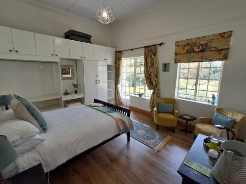a bedroom with a large bed and a living room at Country Barns Guest house in Wakkerstroom