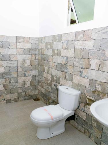 a bathroom with a white toilet and a sink at BTI Leisure Hotel in Kataragama