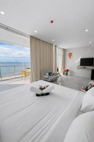a bedroom with a white bed with a view of the ocean at Andante Beach Resort Batangas in San Luis