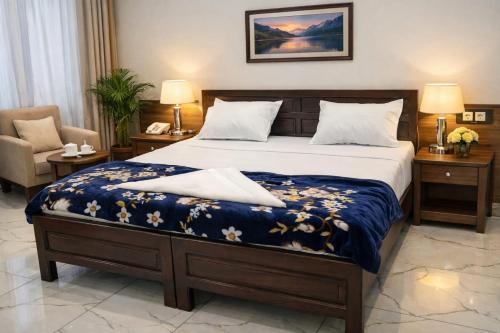 a bedroom with a bed with a blue comforter at Park Palace in Lucknow
