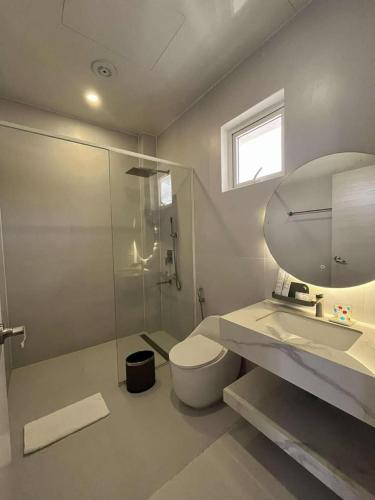 a bathroom with a toilet and a sink and a mirror at Andante Beach Resort Batangas in San Luis