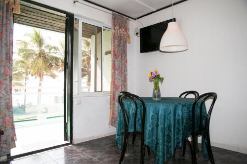 a dining room with a table and chairs and a window at Bungalow Beach Hotel in Serekunda
