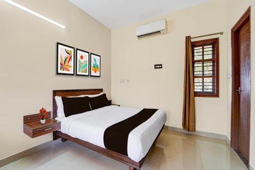 a bedroom with a large bed and a window at Collection O Vazhapadi Bus Terminal Formerly Hotel Phoenix in Salem