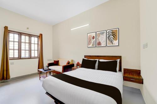 a bedroom with a large bed and a chair at Collection O Vazhapadi Bus Terminal Formerly Hotel Phoenix in Salem