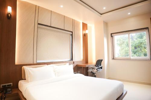 a bedroom with a white bed and a window at DHANUSH STAYS - A Boutique Accommodation in Varanasi