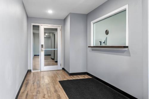a hallway with white walls and a window and a rug at WoodSpring Suites Memphis East I-40 in Memphis