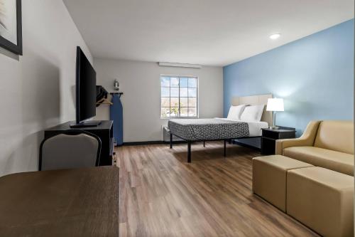 a hotel room with a bed and a couch at WoodSpring Suites Memphis East I-40 in Memphis