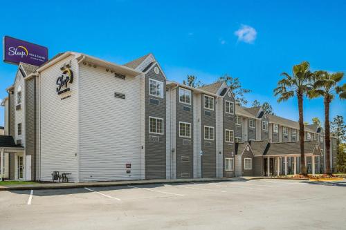 a large building with a parking lot in front of it at Sleep Inn & Suites Tallahassee-Capitol in Tallahassee