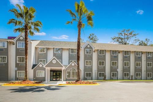 a large building with palm trees in front of it at Sleep Inn & Suites Tallahassee-Capitol in Tallahassee