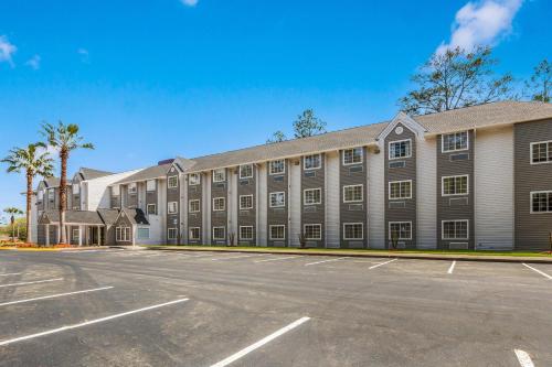 a large building with a parking lot in front at Sleep Inn & Suites Tallahassee-Capitol in Tallahassee