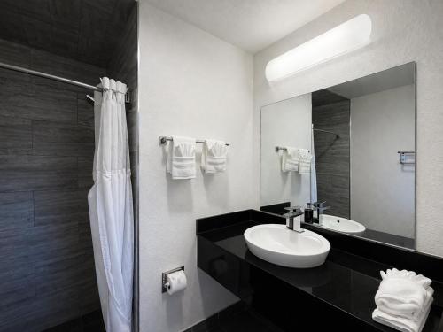 a black and white bathroom with a sink and a mirror at Fisherman's Cove Inn in Monterey