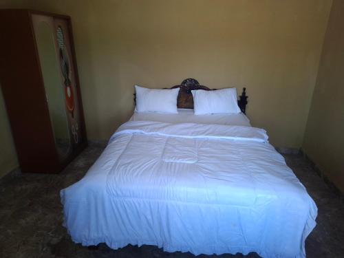 a bed in a room with a white bedspread at Amanda Ekas Homestay in Pulau Gilkaliantan