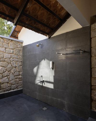 a bathroom with a sink and a stone wall at Avadale Munnar (Stag Groups Not Allowed) in Chinnakanal