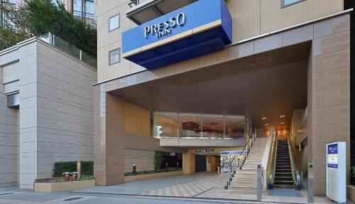 a building with a pharmacy sign on the side of it at Keio Presso Inn Shinjuku in Tokyo