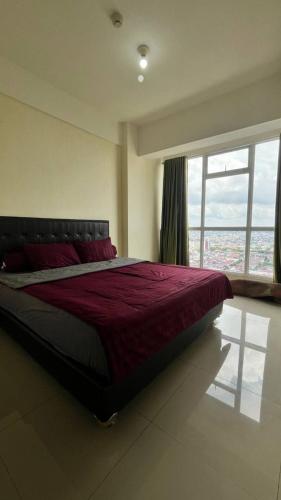 a bedroom with a large bed with a large window at Vida View Apartment by Vida Connect in Makassar