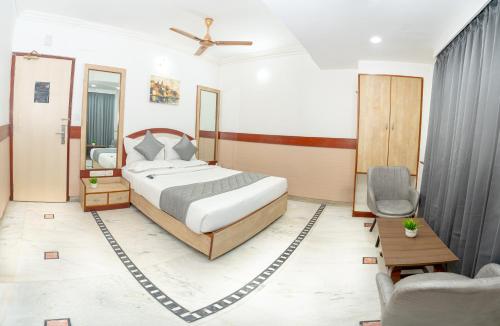 a bedroom with a king sized bed and a chair at Hotel The Black Diamond in Bangalore